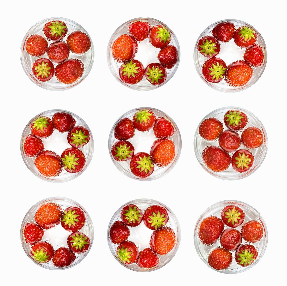 Several glasses of water with strawberries (from above)