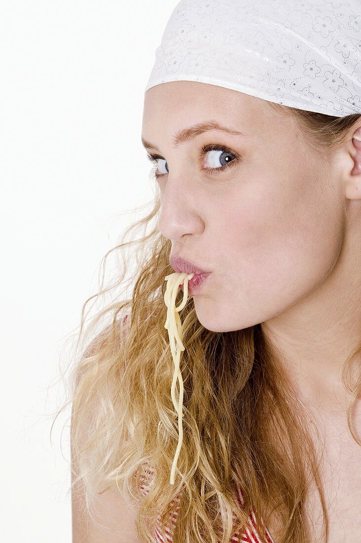 Young woman sucking spaghetti