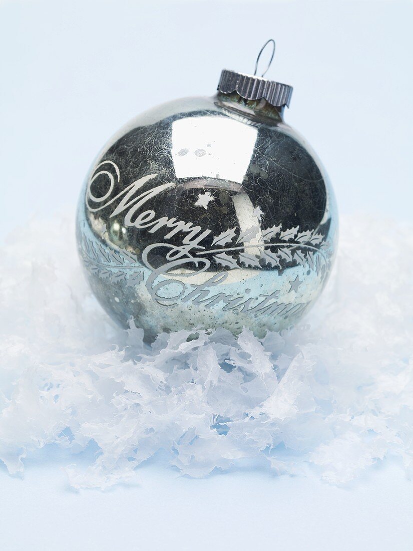 Antique silver Christmas bauble on artificial snow
