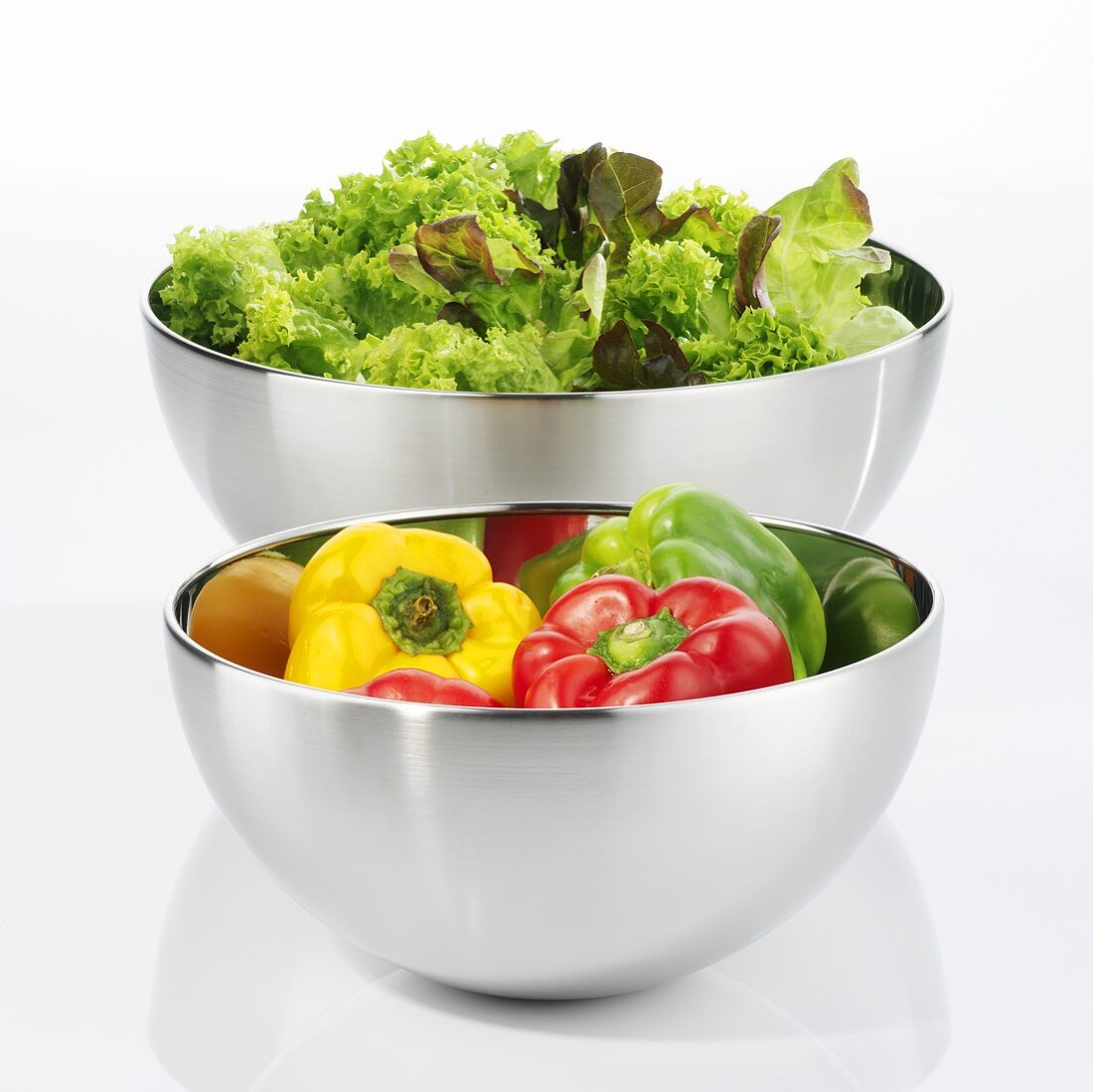 Peppers and green salad in stainless steel bowls