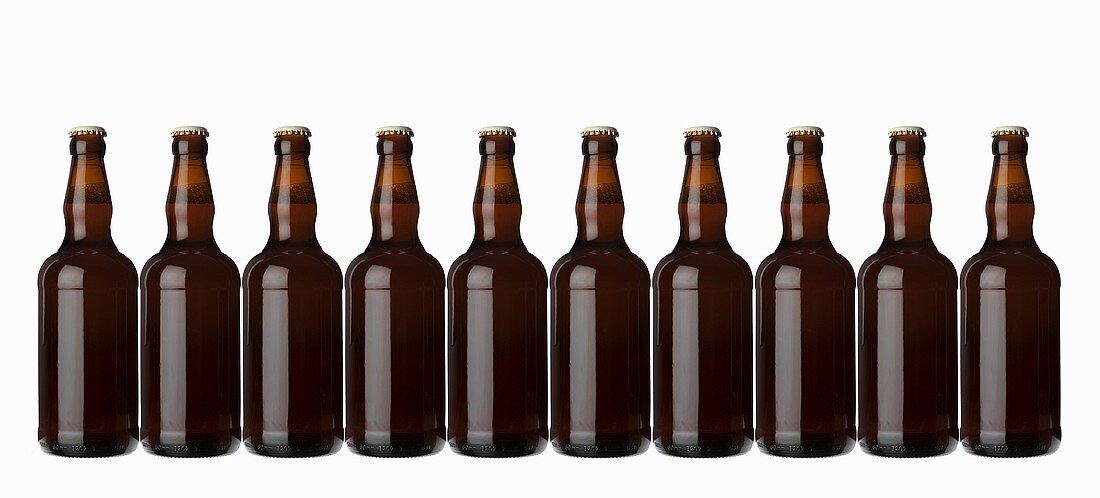 Ten brown bottles standing in a row (lager)