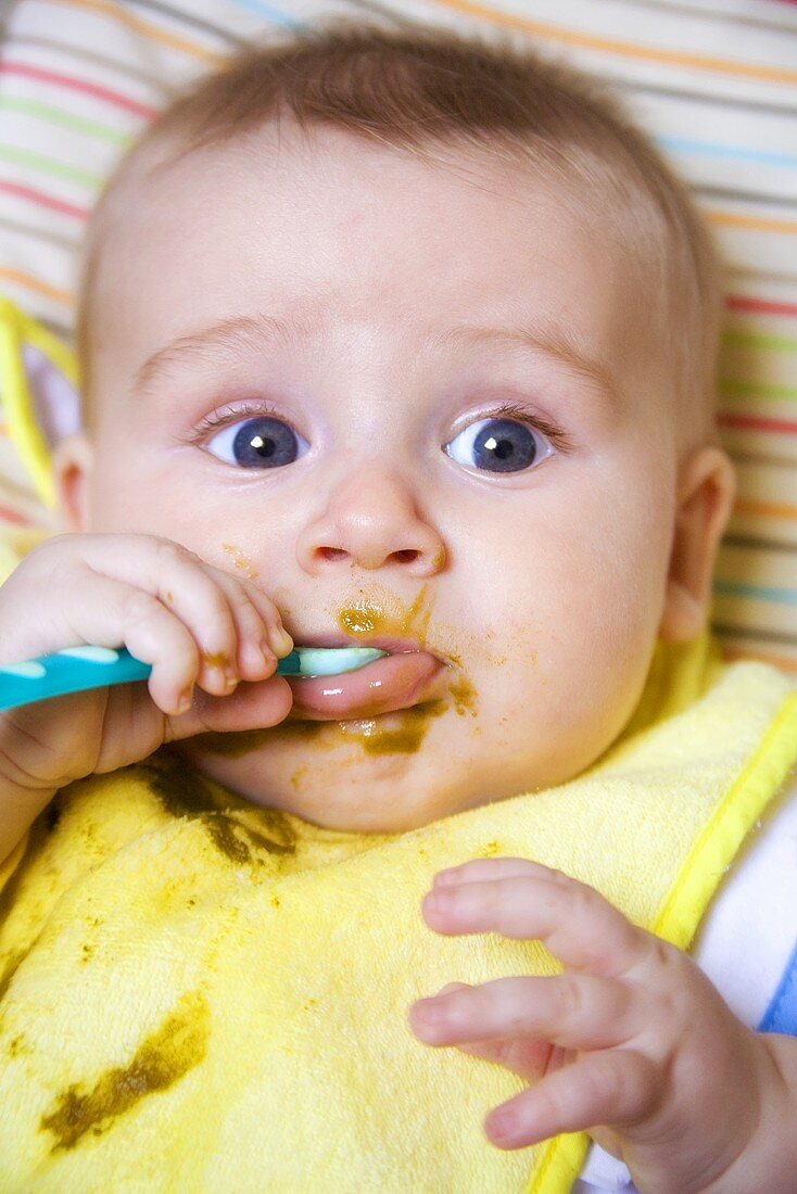Baby eating baby food from spoon