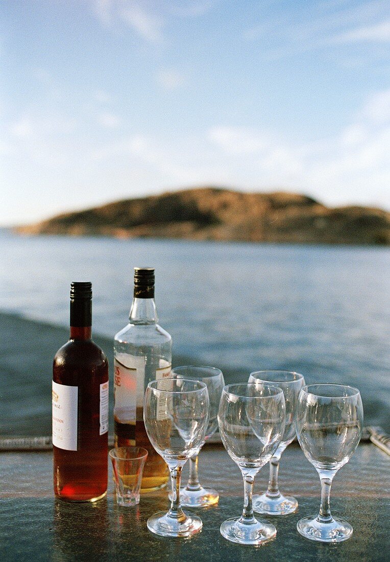 Drinks and empty glasses on tray by sea