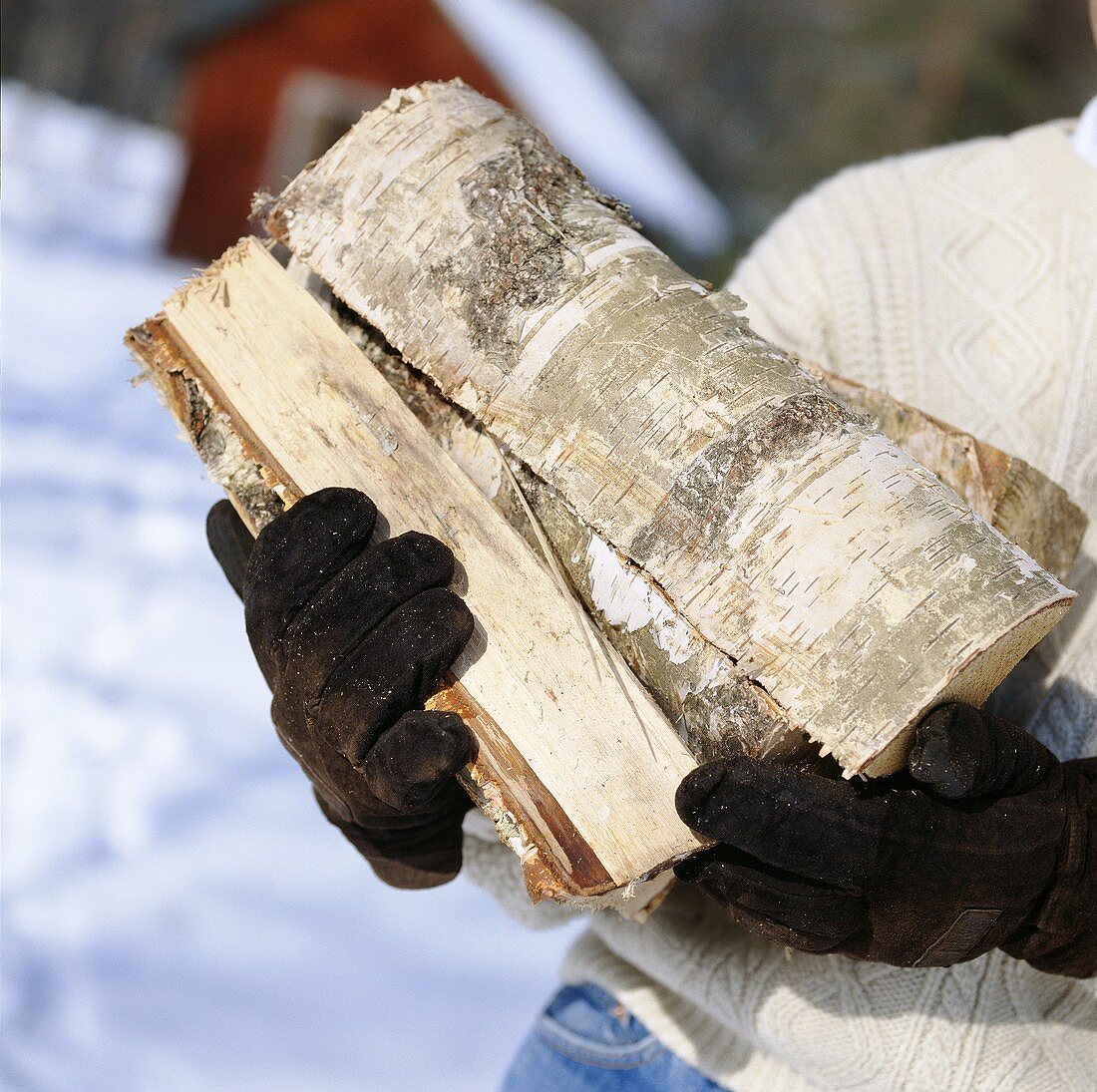 Man carrying firewood out of doors