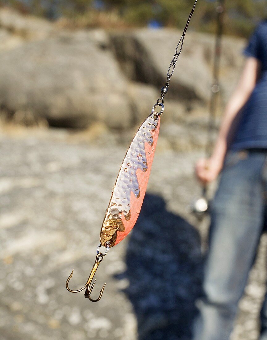 Person holding fishing line with hook