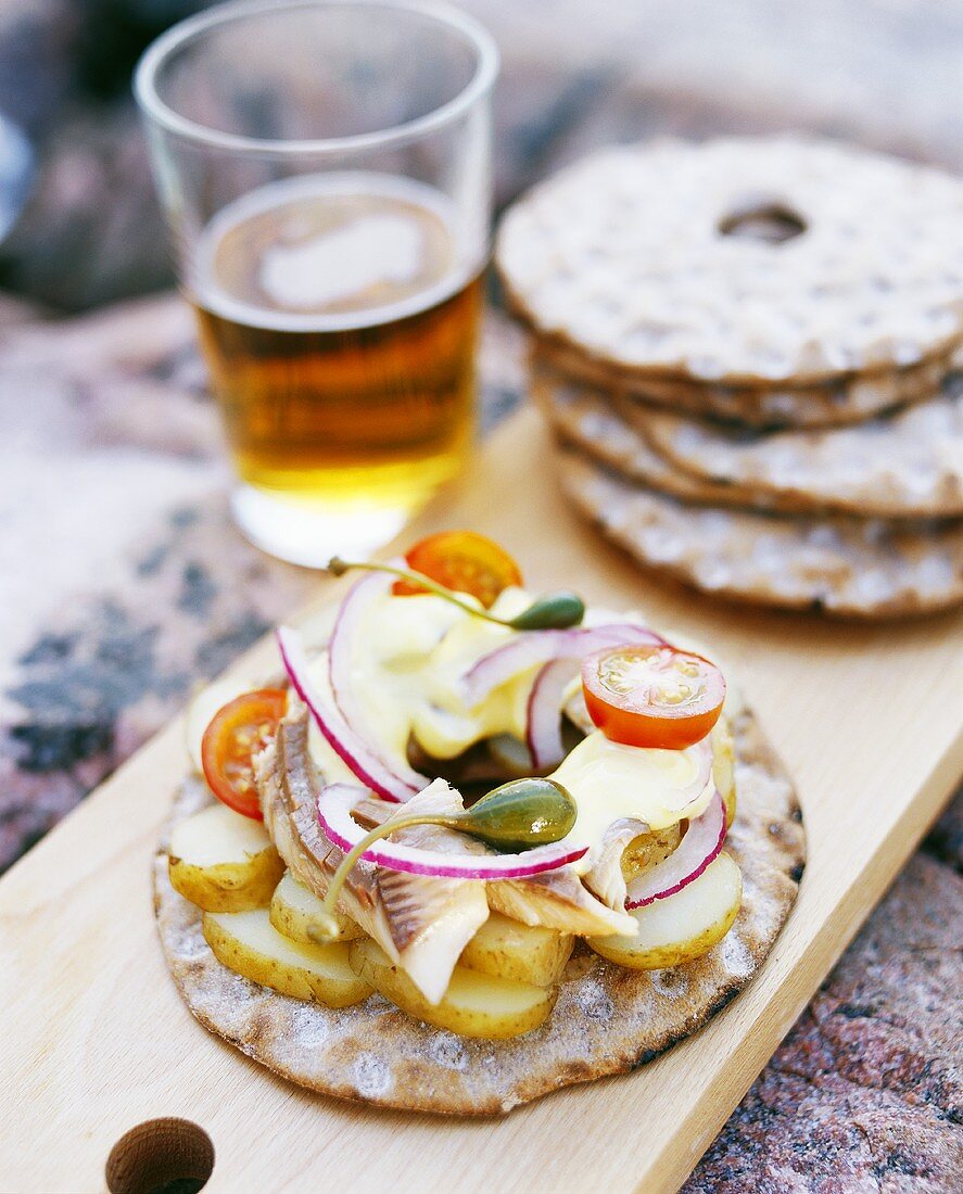 Rundes Knäckebrot belegt mit Kartoffeln, Fisch und Mayonnaise