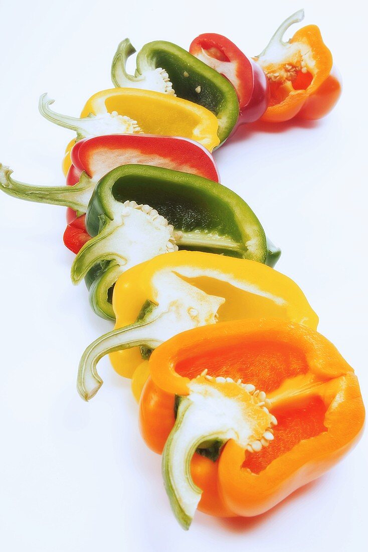 Different coloured pepper halves in a row