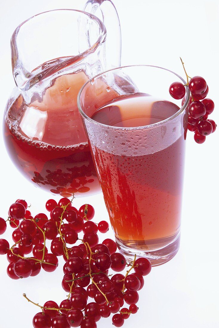 Redcurrant juice in glass and jug