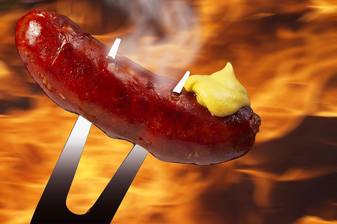 Grillwurst mit Senf auf Fleischgabel