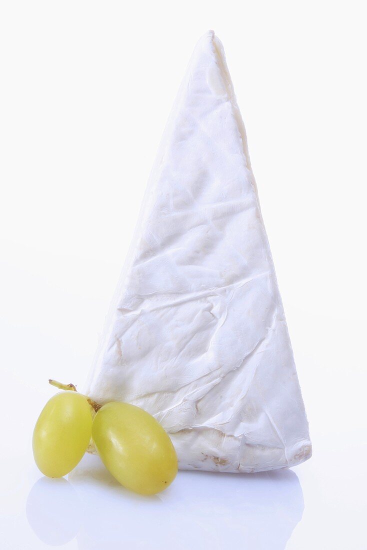 A piece of Brie and green grapes