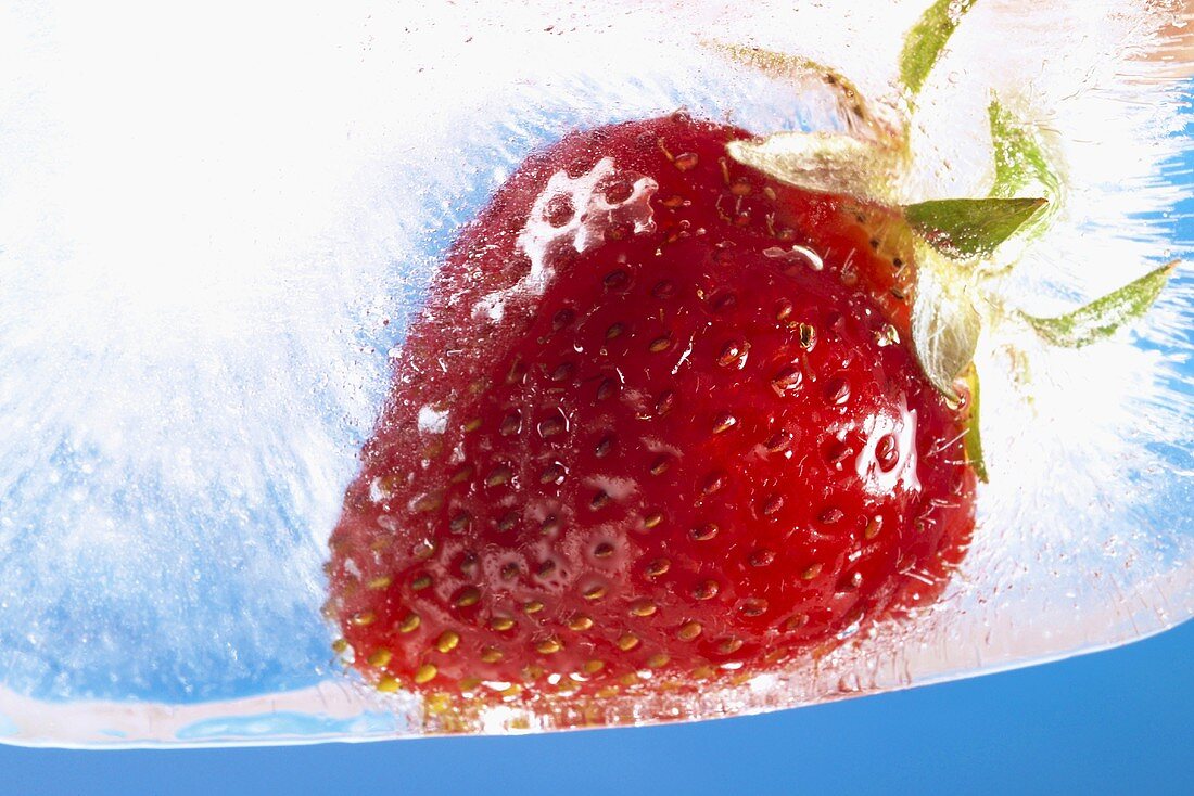 Frozen strawberry in block of ice (close-up)