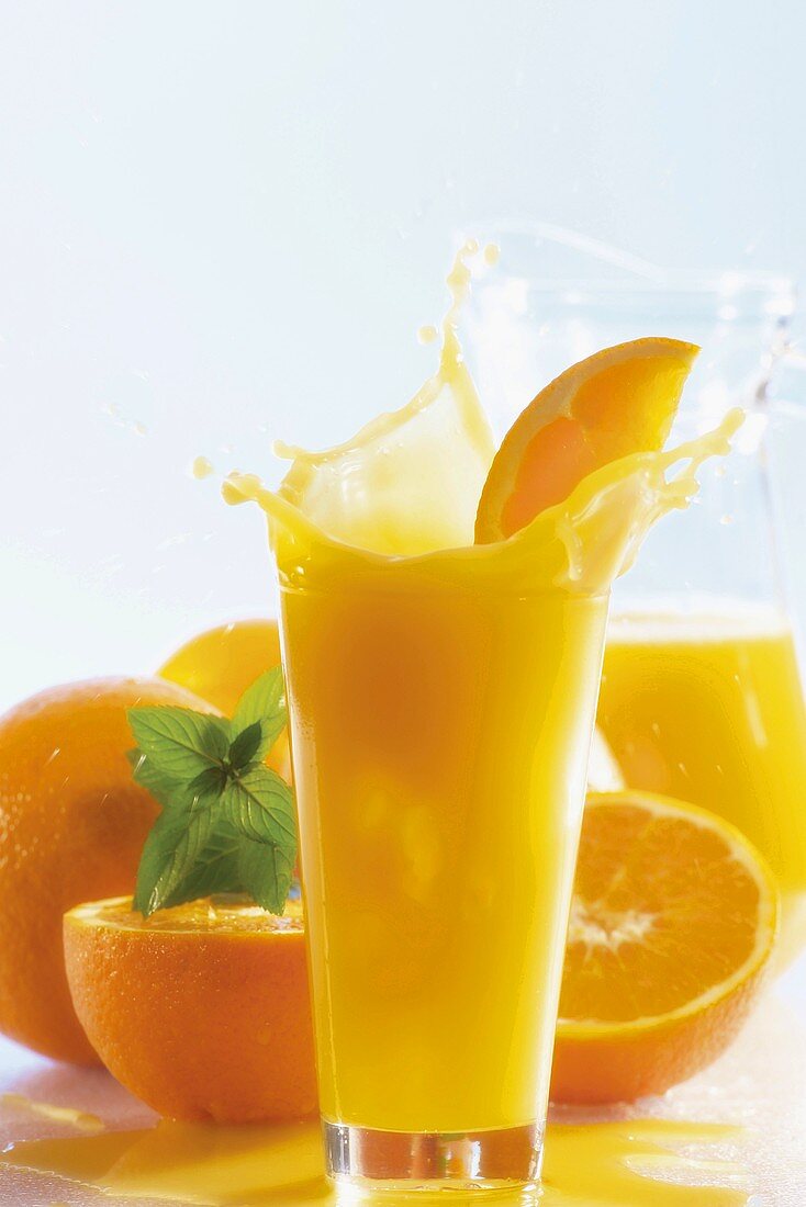 Orangensaft und frische Orangen