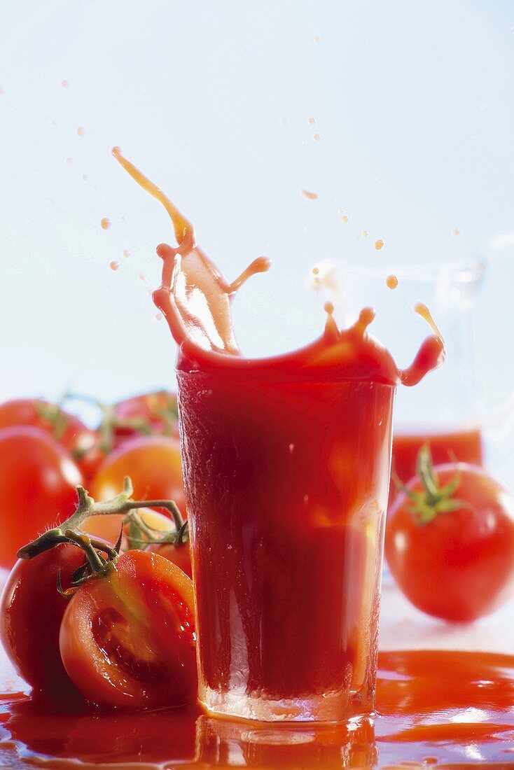 Tomato juice splashing out of glass