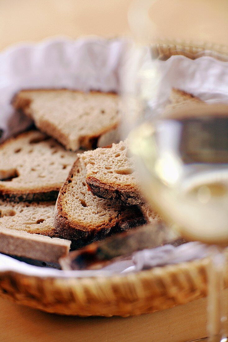 Bread basket and glass of white wine