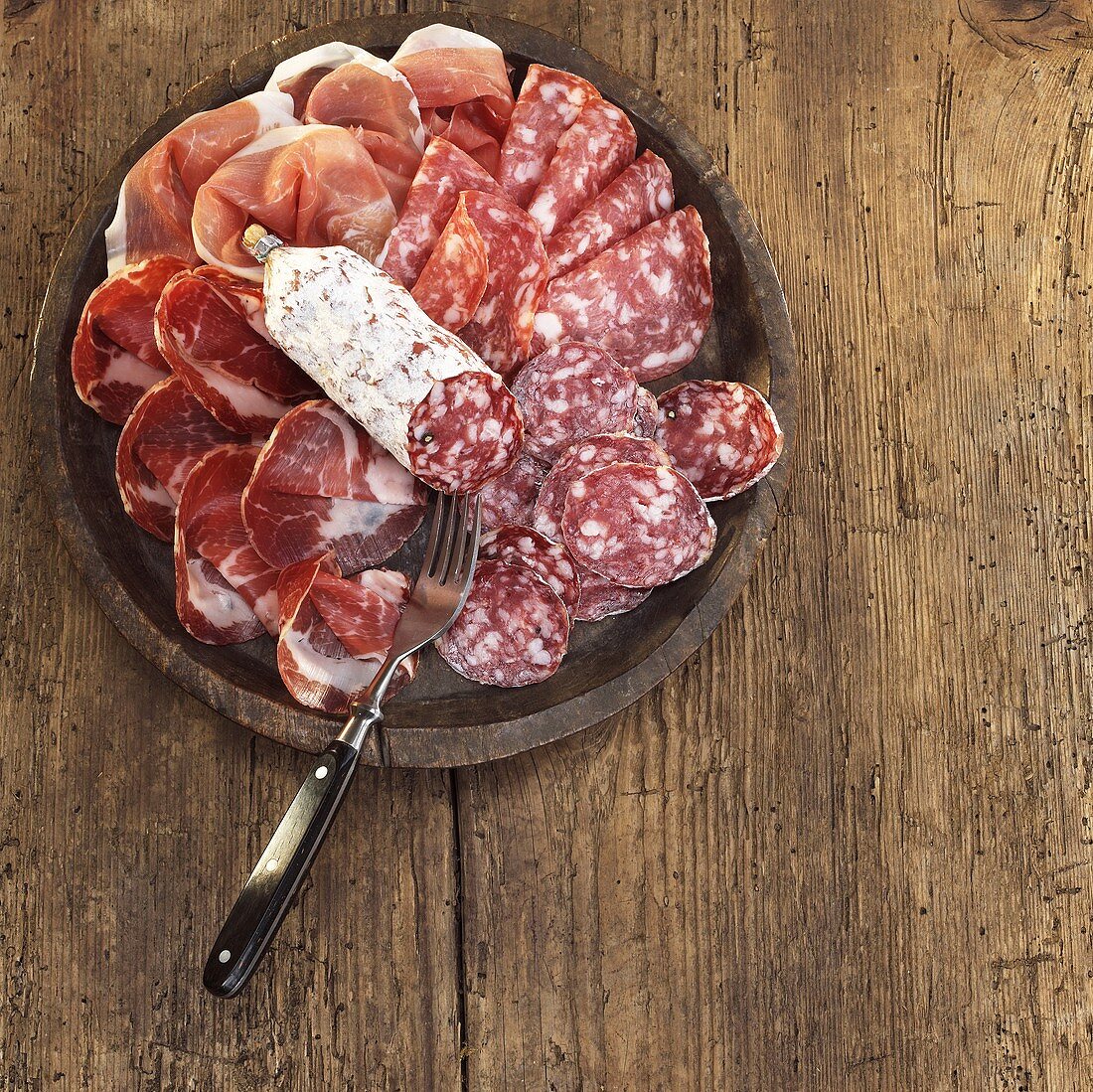 Sliced salami and ham on plate, elevated view