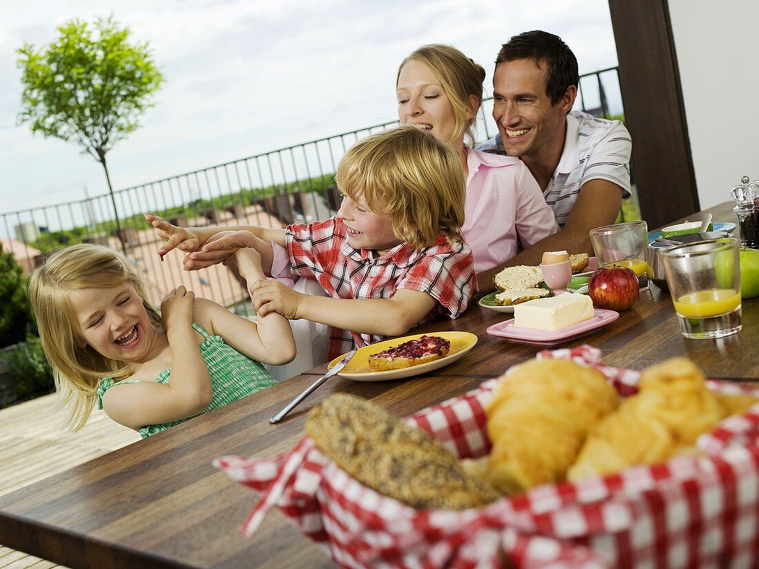 Familie frühstückt auf der Terrasse