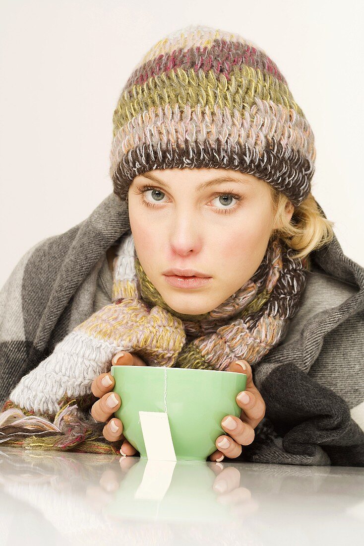 Woman in winter clothes with a bowl of tea