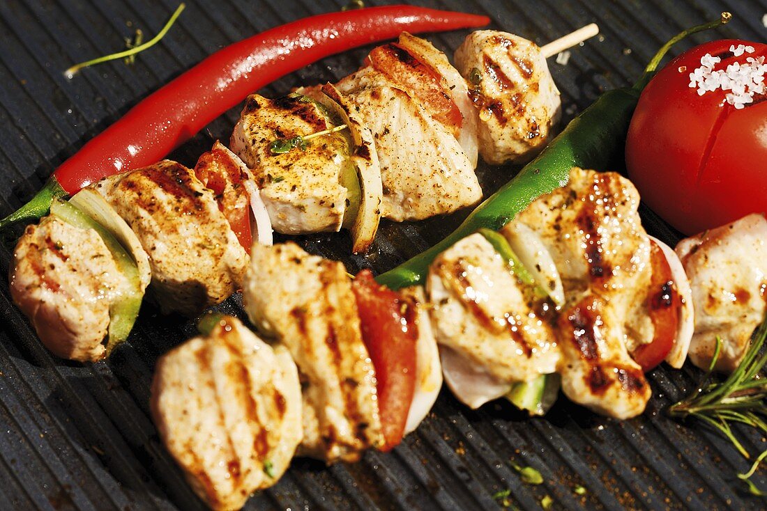 Meat kebabs and vegetables on barbecue rack