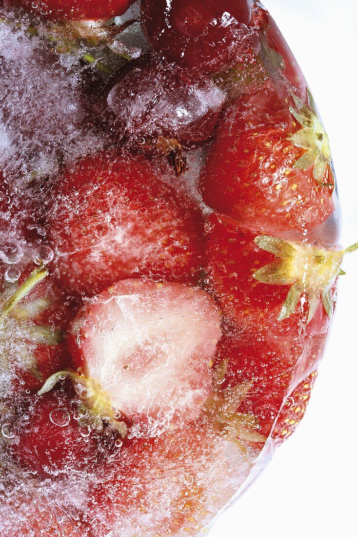 Rote Früchte (Erdbeeren, Kirschen) im Eisblock