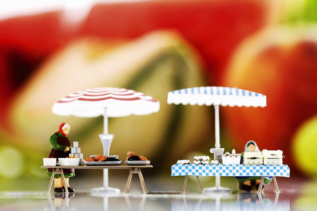 Spielzeugmarktstände mit Figuren, Obst im Hintergrund