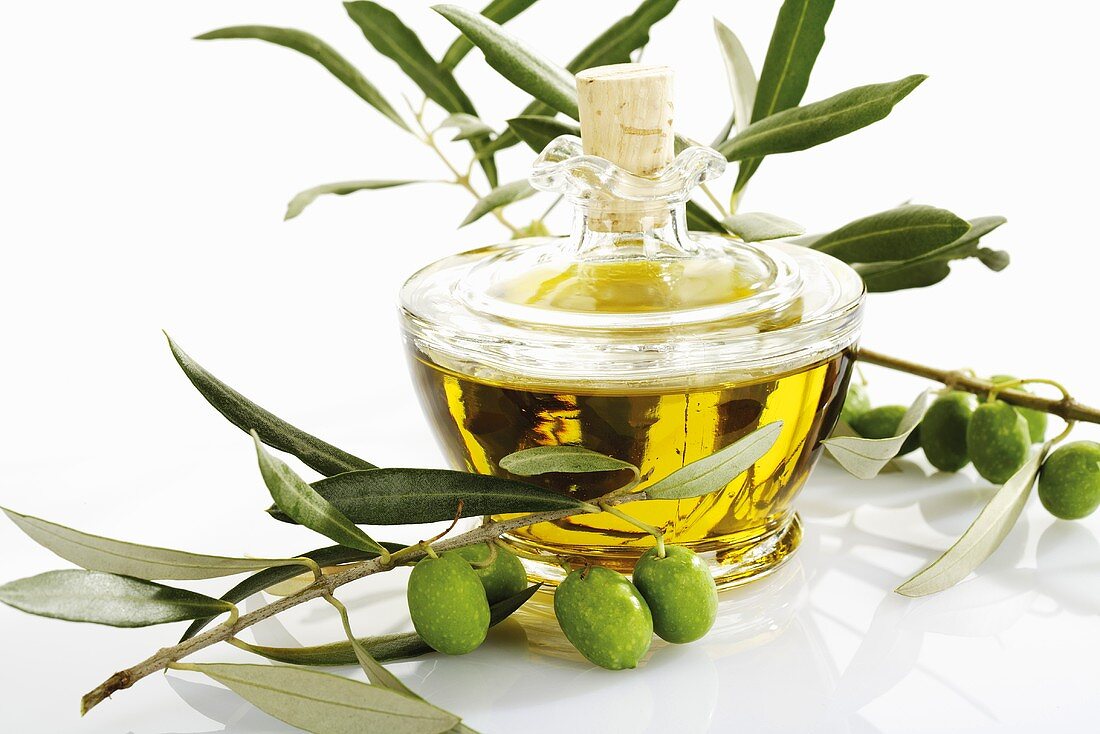 Olivenöl und Zweige mit frischen Oliven