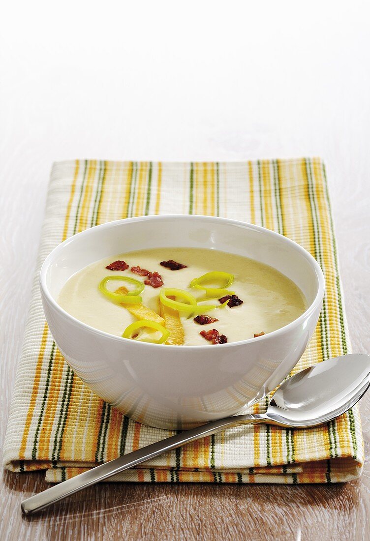 Rutabaga vegetable cream soup with bacon on napkin, spoon aside