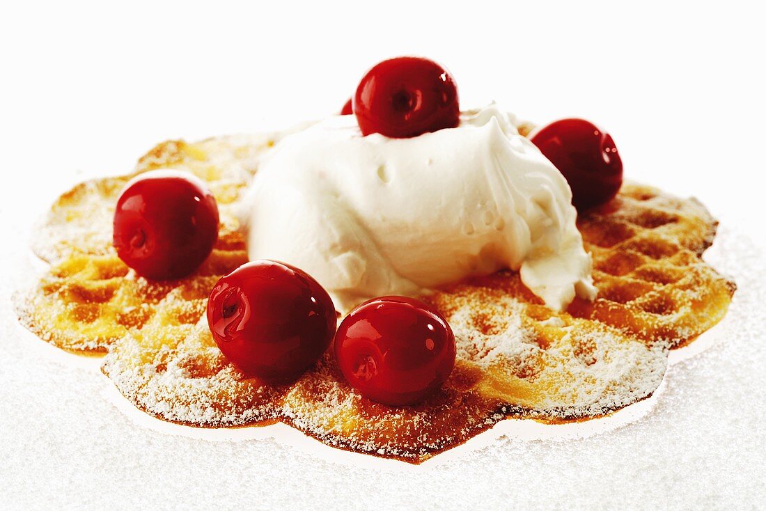 Waffle with cream and cherries, close-up