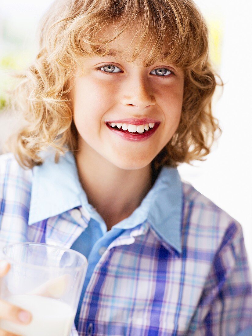 Lächelnder Junge mit einem Glas Milch