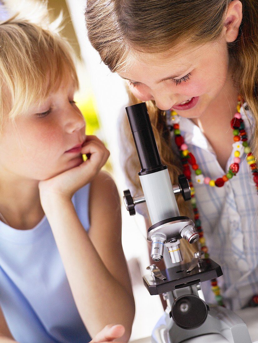 Zwei Kinder mit einem Mikroskop