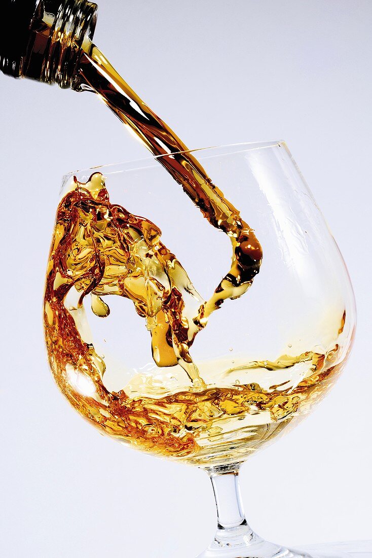 Cognac in Glas gießen