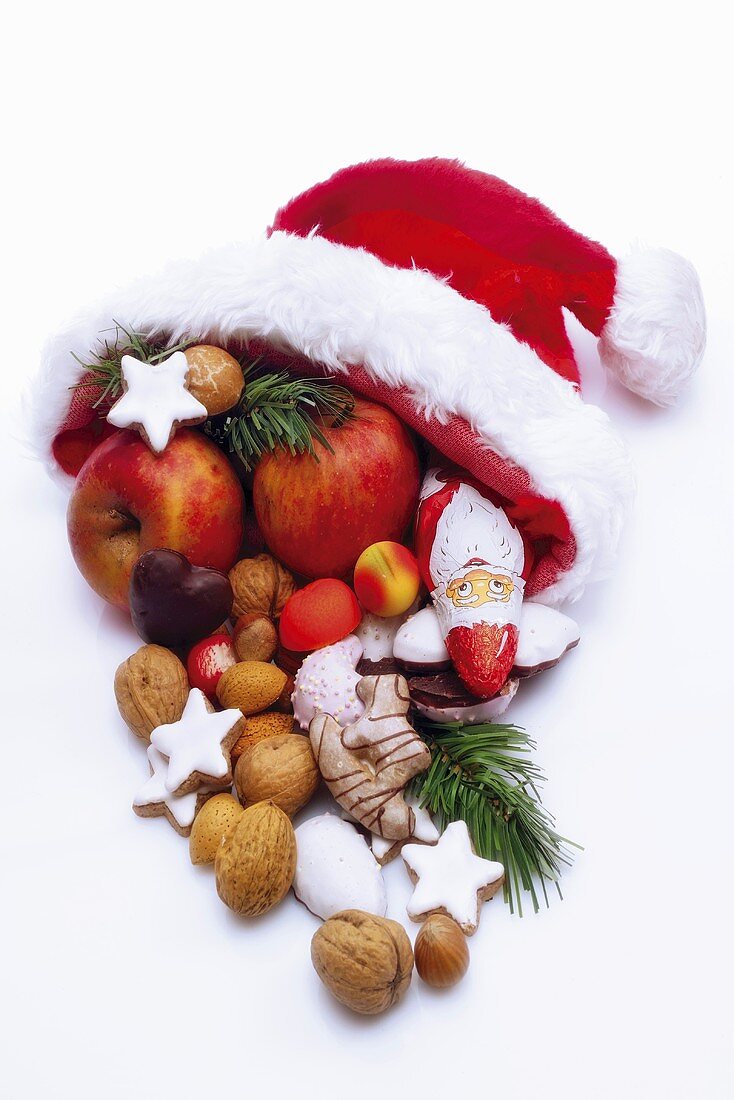 Nikolausmütze mit Weihnachtsplätzchen, Süssigkeiten, Äpfeln und Nüssen