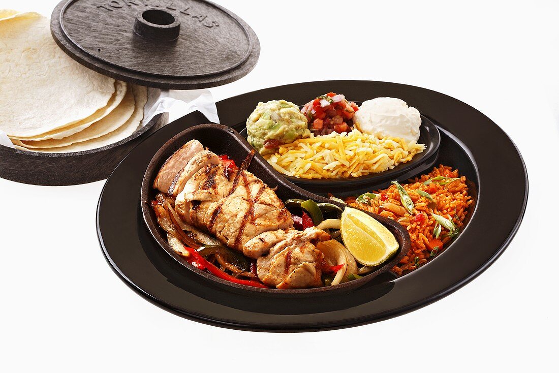 Chicken fajita with accompaniments and tortillas