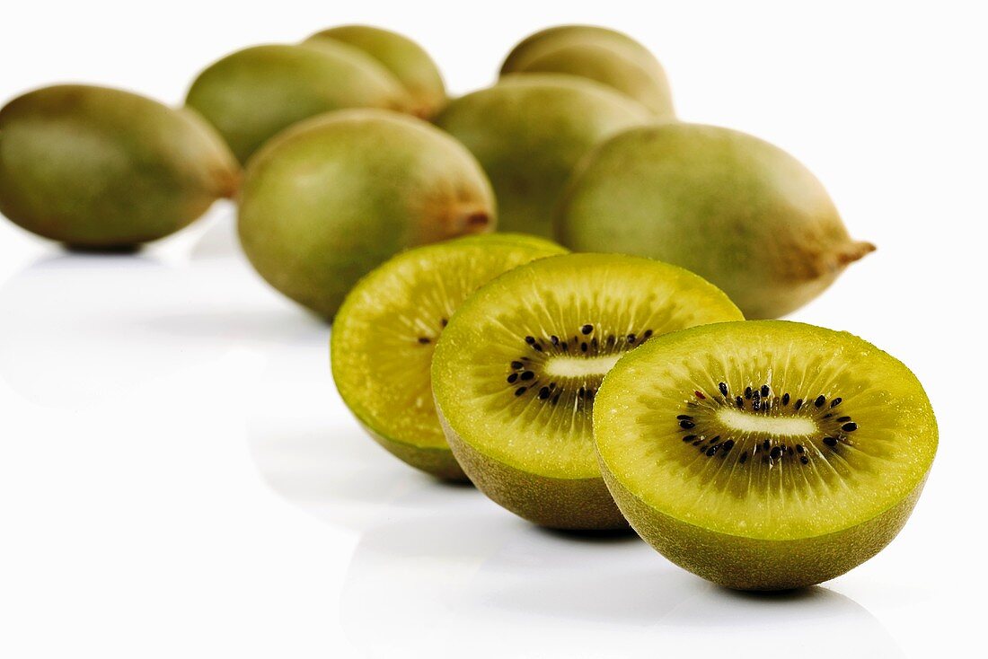 Whole and halved kiwi fruits (variety: Golden Kiwi)