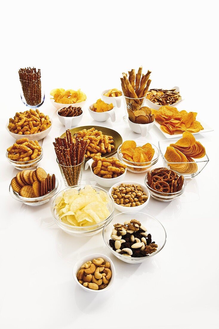 Viele verschiedene Snacks (Salzgebäck, Studentenfutter, Chips, Cracker, Nüsse)