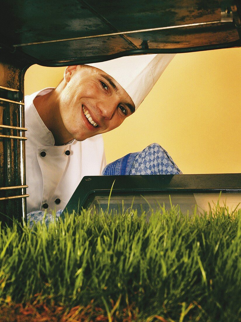 Chef looking at lawn in oven