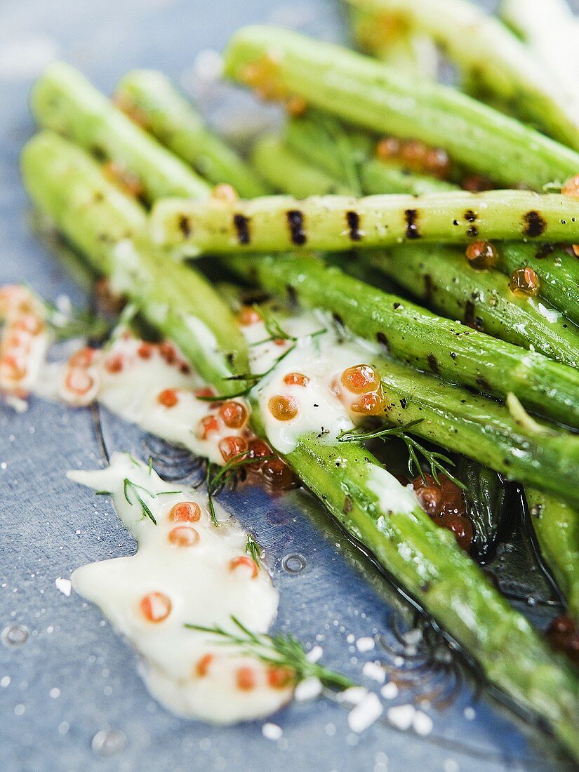 Gegrillter grüner Spargel mit Sauerrahm und Kaviar