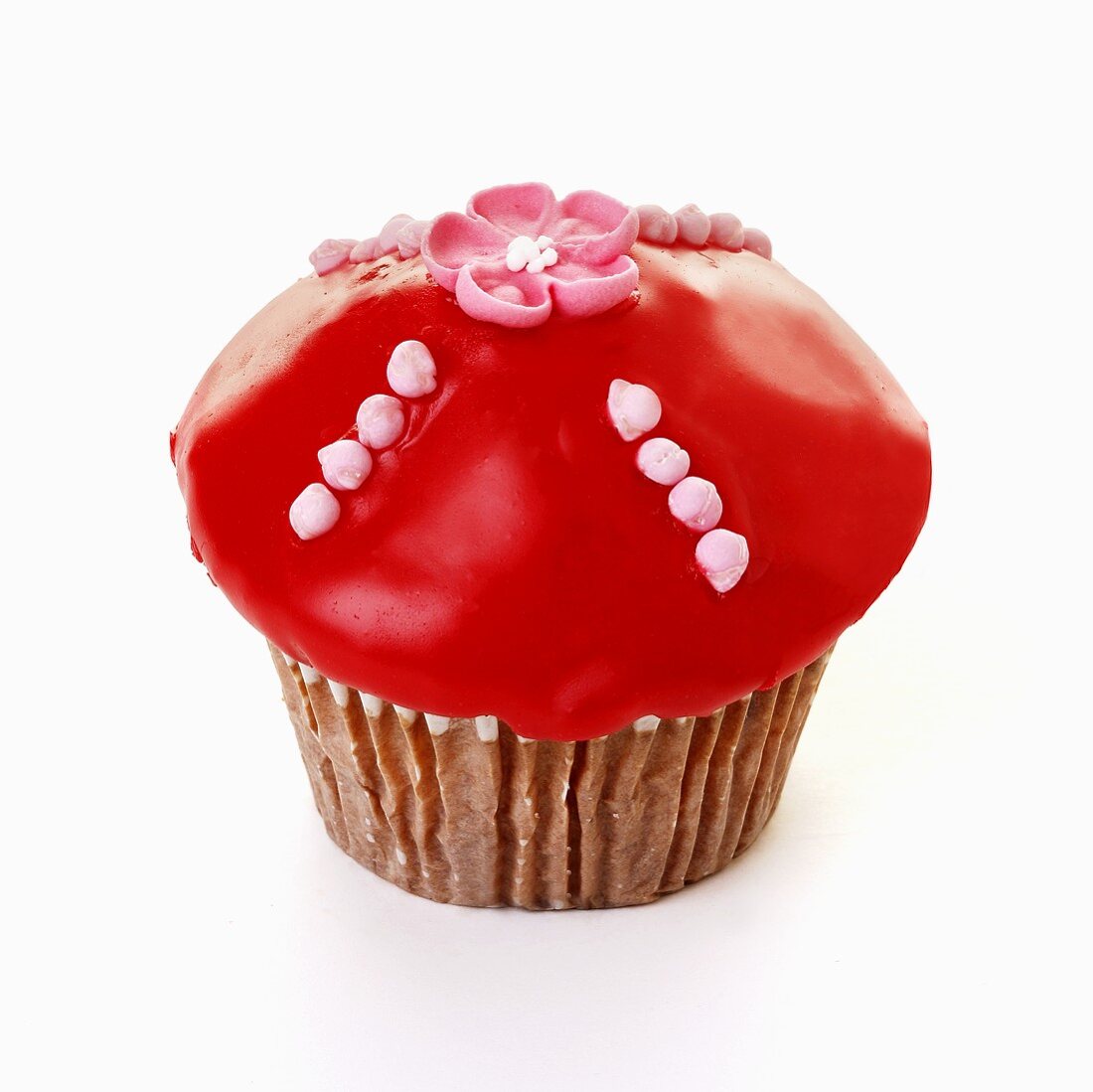 Muffin mit rotem Zuckerguss und Zuckerblüte