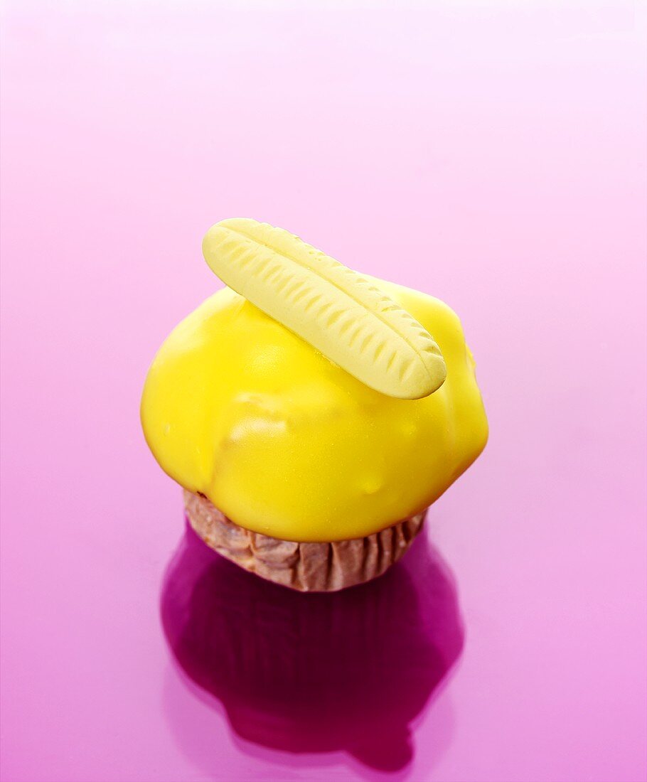 Muffin mit gelbem Zuckerguss und Fruchtgummi