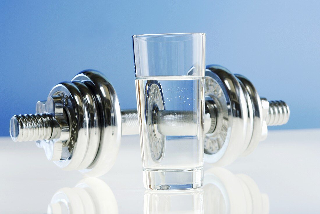 Glass of water, dumbbell in background