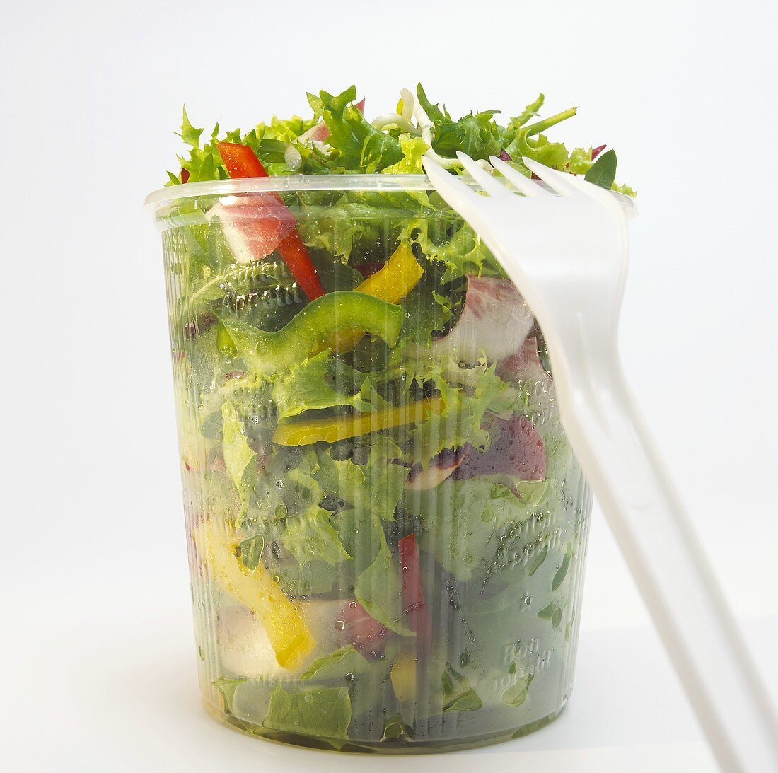 Mixed salad in plastic bin, close-up