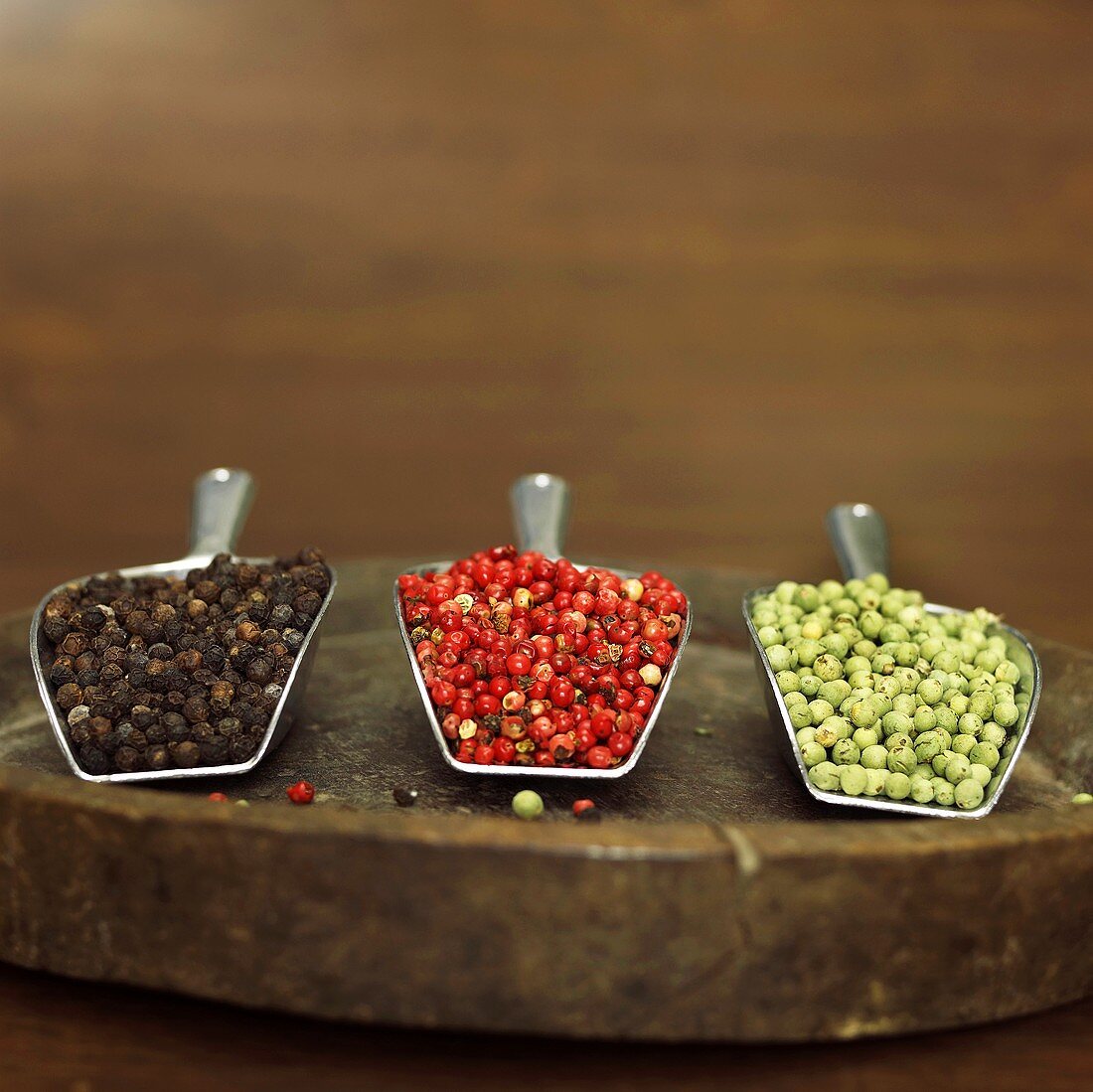 Black, red and green peppercorns in scoops