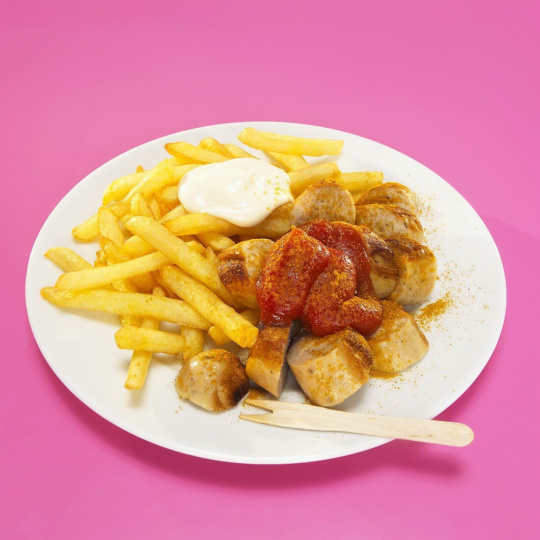 Currywurst and French fries with sauce in plate, close-up