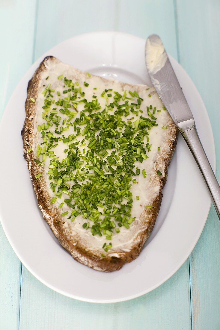 Bread and butter on plate with chives