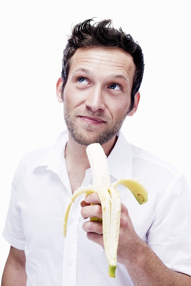 Junger Mann isst Banane