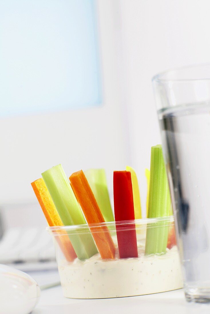 Vegetable sticks with dip on office desk