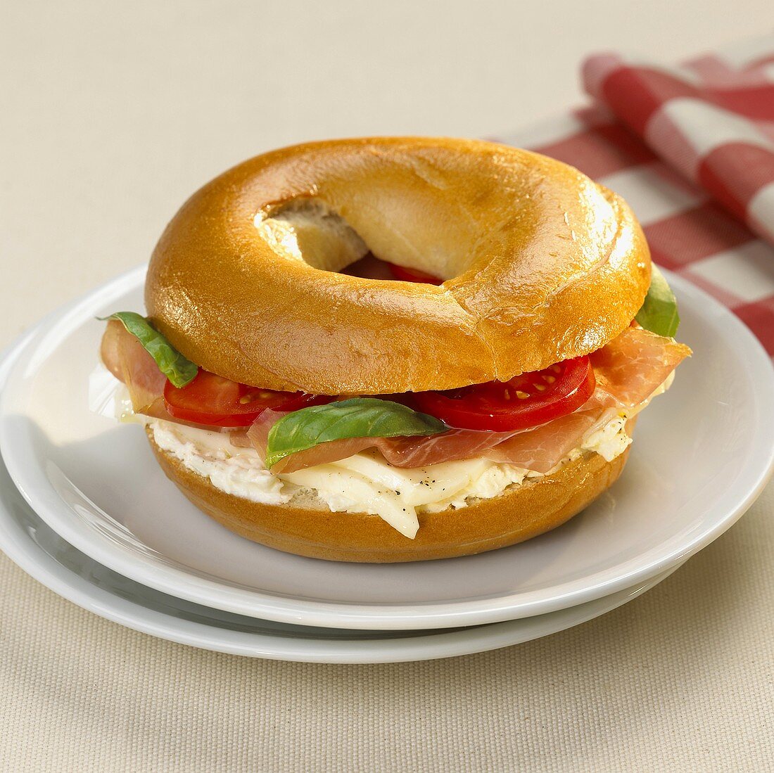 Bagel filled with tomato, mozzarella and prosciutto