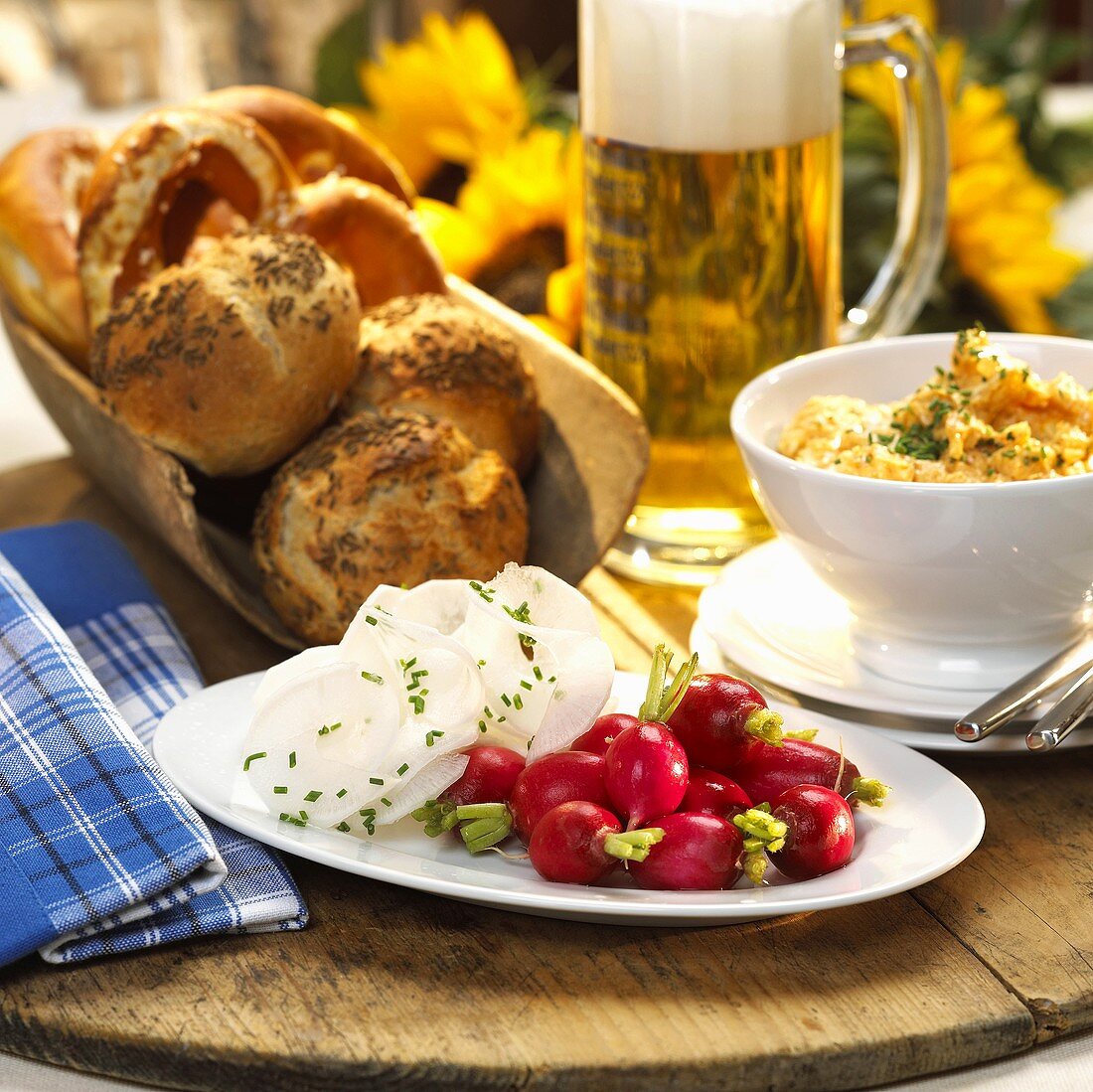 Brotzeit mit Radieschen, Obatzda, Brötchen und Bier (Bayern)