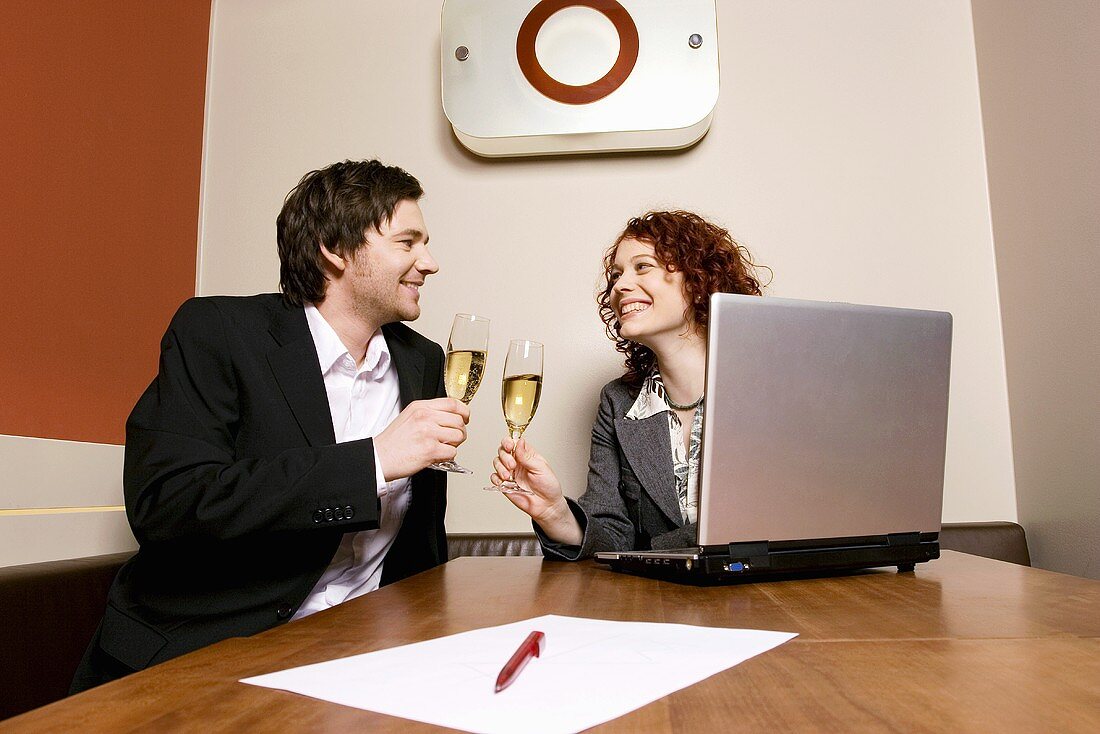 Couple drinking champagne in office