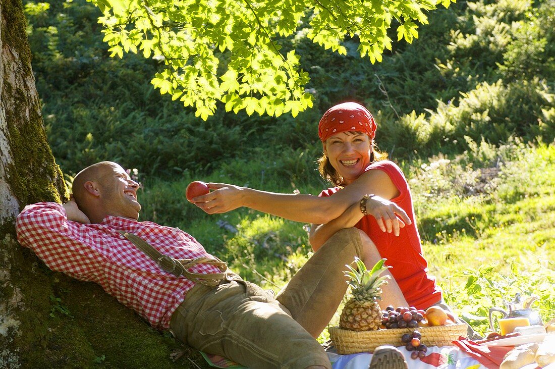 Couple having picnic under tree