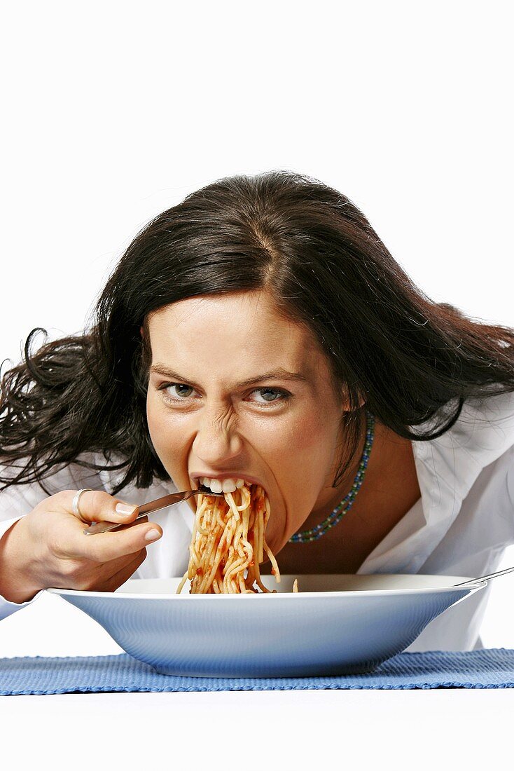 Young woman eating spaghetti